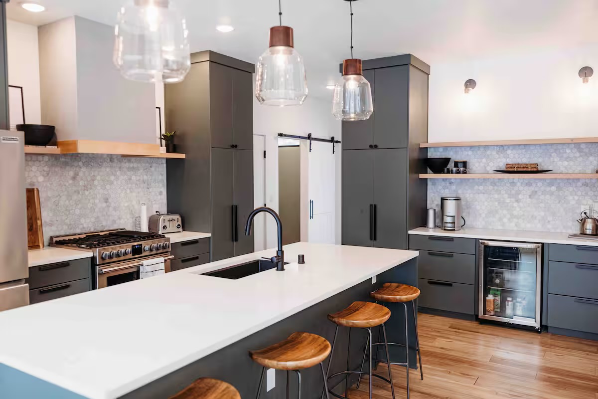 Full kitchen with island seating and bar fridge.